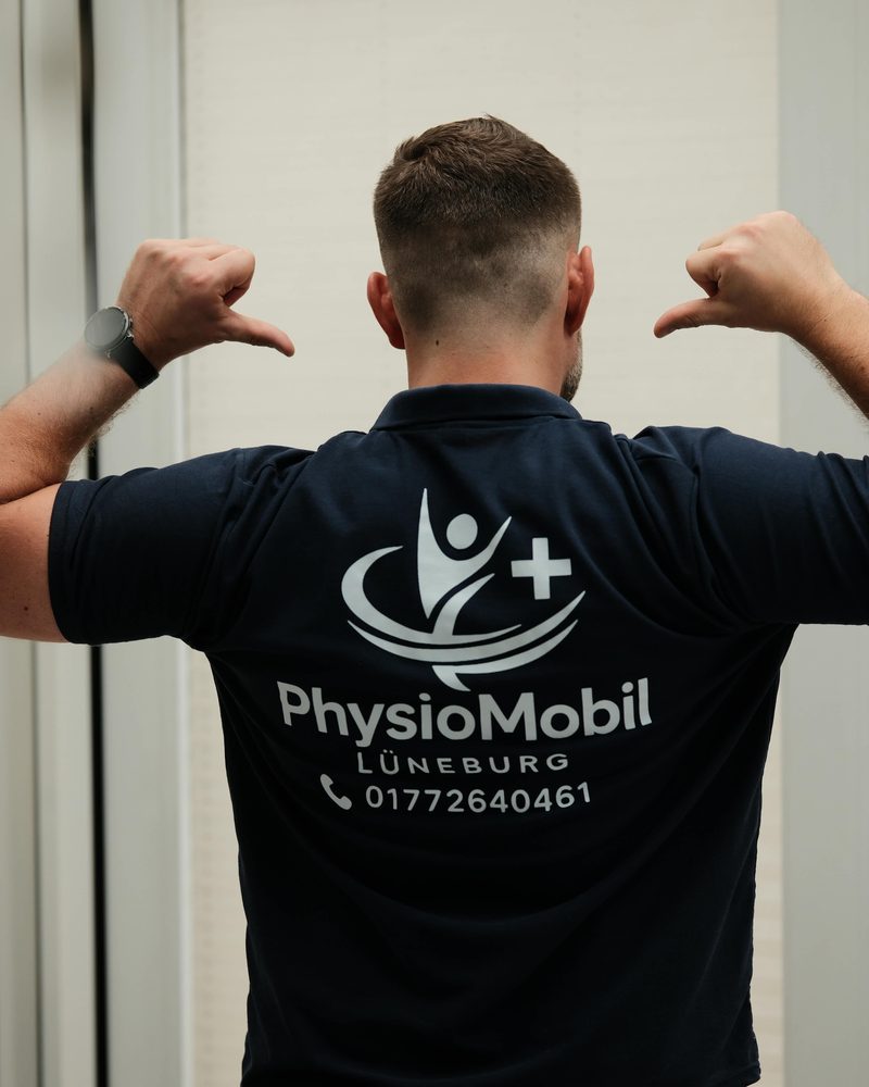 Jan-Tobias Worthmann von hinten im Poloshirt von PhysioMobil Lüneburg, darauf das Logo und die Rufnummer 0177 264 0461